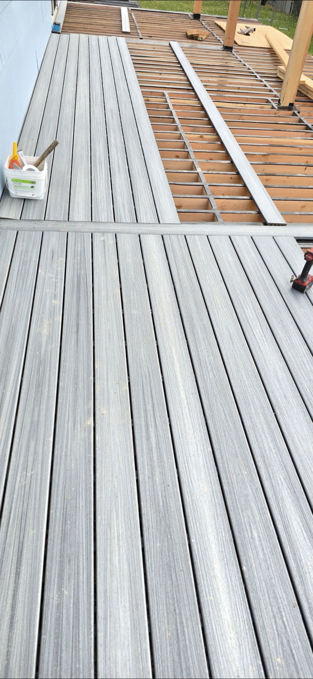 New gray composite decking installed over wood joists during a Montana deck rebuild