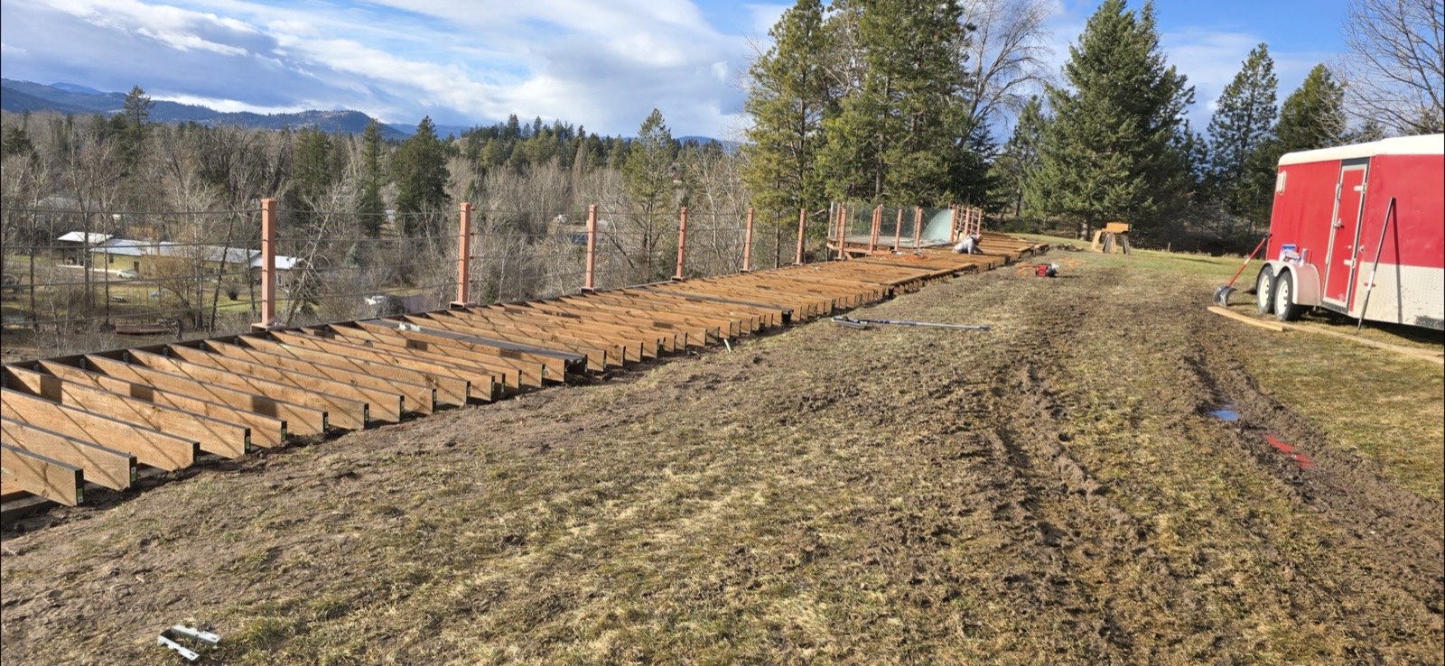 Deck and walkway framing along a hillside with Montana mountain views